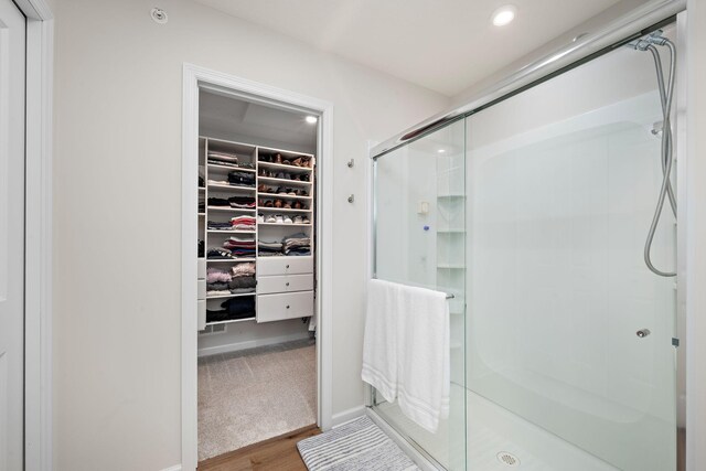 6779 Bluestem Way, Minnetrista, MN 55331 - full bathroom with recessed lighting, baseboards, a shower stall, wood finished floors, and a spacious closet