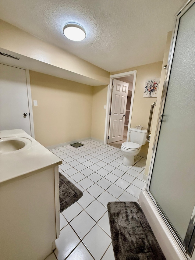 full bath featuring a textured ceiling, tile patterned flooring, toilet, visible vents, and a shower stall