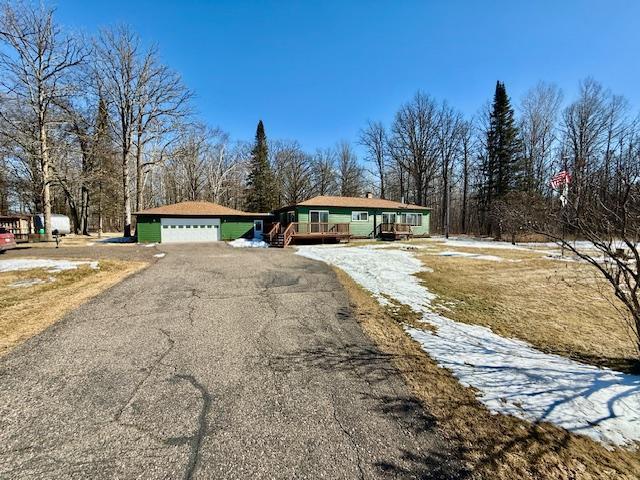 view of front of home with driveway, a garage, and an outdoor structure