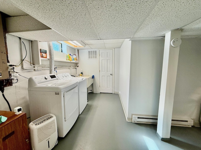 washroom with baseboards, visible vents, baseboard heating, and separate washer and dryer