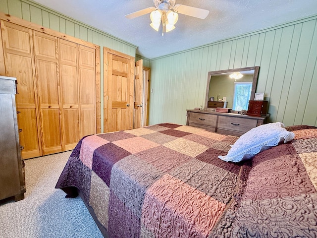 bedroom featuring carpet floors, ceiling fan, and a textured ceiling