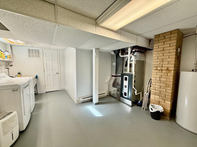 finished basement featuring visible vents, a drop ceiling, baseboard heating, separate washer and dryer, and gas water heater