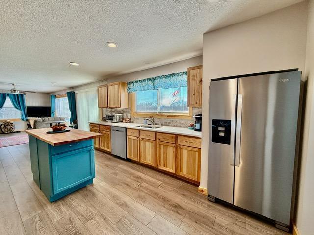 45936 State Highway 65, Mcgregor, MN 55760 - kitchen with stainless steel appliances, wood counters, light wood-style flooring, a textured ceiling, and a sink