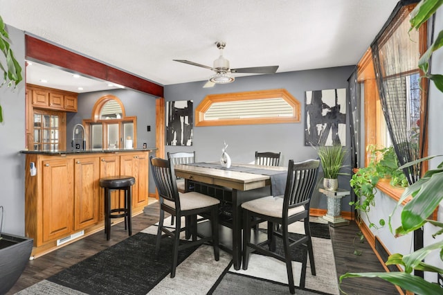 dining space featuring visible vents, baseboards, dark wood-type flooring, and a ceiling fan