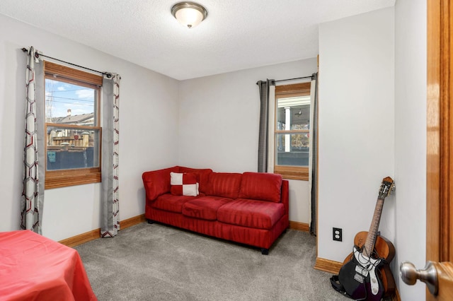 living area with baseboards, a healthy amount of sunlight, and carpet flooring