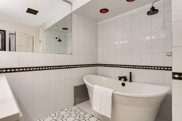 bathroom with tiled shower, a soaking tub, tile walls, and tile patterned flooring