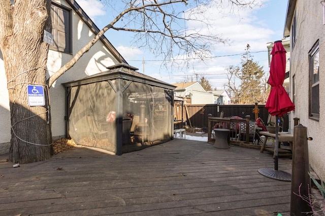 wooden terrace featuring a gazebo and fence