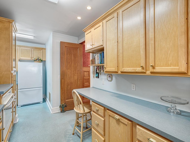857 Fairmount Ave, Saint Paul, MN 55105 - kitchen with freestanding refrigerator, light brown cabinetry, built in desk, and recessed lighting