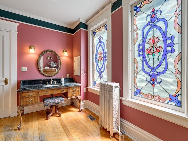 857 Fairmount Ave, Saint Paul, MN 55105 - bathroom featuring hardwood / wood-style floors, ornamental molding, radiator heating unit, and vanity