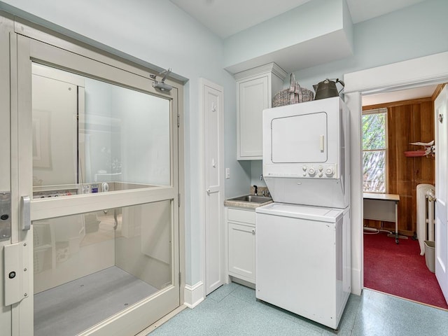 857 Fairmount Ave, Saint Paul, MN 55105 - laundry area featuring stacked washer / drying machine, radiator, and cabinet space