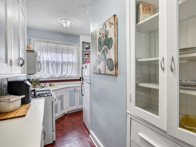 857 Fairmount Ave, Saint Paul, MN 55105 - kitchen with white appliances, light countertops, a textured ceiling, and white cabinets
