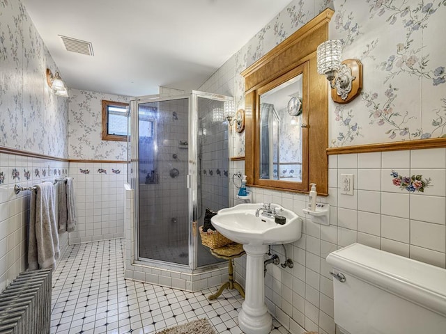857 Fairmount Ave, Saint Paul, MN 55105 - full bathroom featuring tile walls, wallpapered walls, a stall shower, tile patterned flooring, and wainscoting