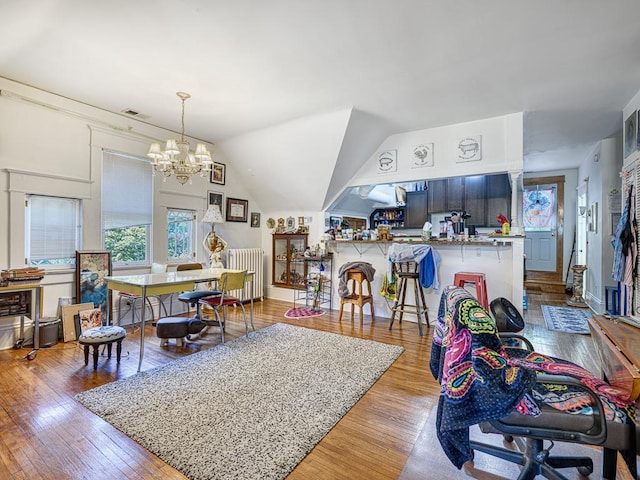 857 Fairmount Ave, Saint Paul, MN 55105 - living room featuring radiator, hardwood / wood-style flooring, a chandelier, and lofted ceiling