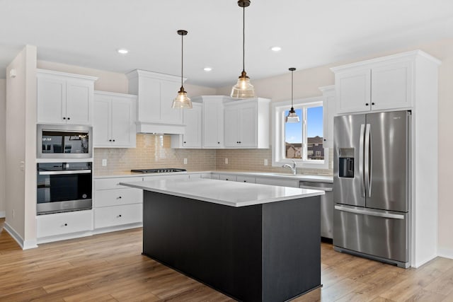 kitchen with light wood-type flooring, white cabinetry, appliances with stainless steel finishes, and backsplash