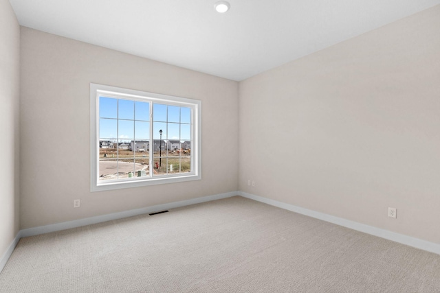 unfurnished room featuring baseboards, visible vents, and carpet flooring