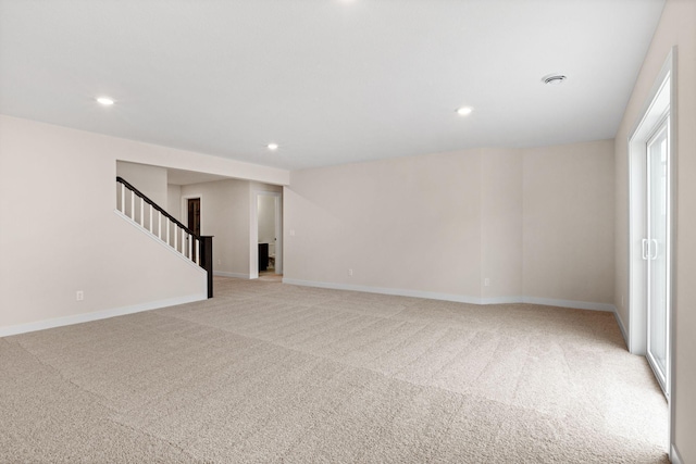 spare room featuring stairs, recessed lighting, baseboards, and light colored carpet