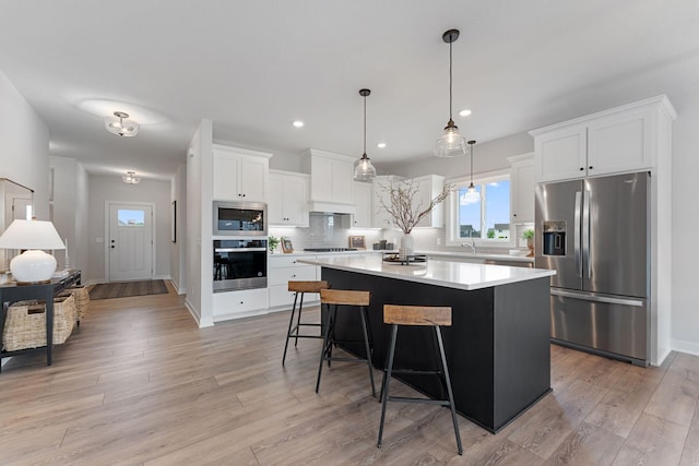 17771 Elkwood Ct, Lakeville, MN 55024 - kitchen with appliances with stainless steel finishes, decorative backsplash, a kitchen island, light countertops, and white cabinets