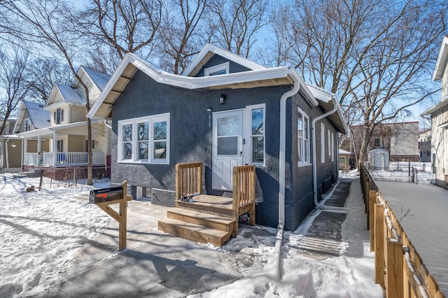 bungalow-style home featuring stucco siding