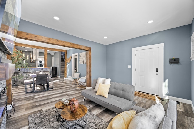 living area featuring stairs, baseboards, wood finished floors, and recessed lighting