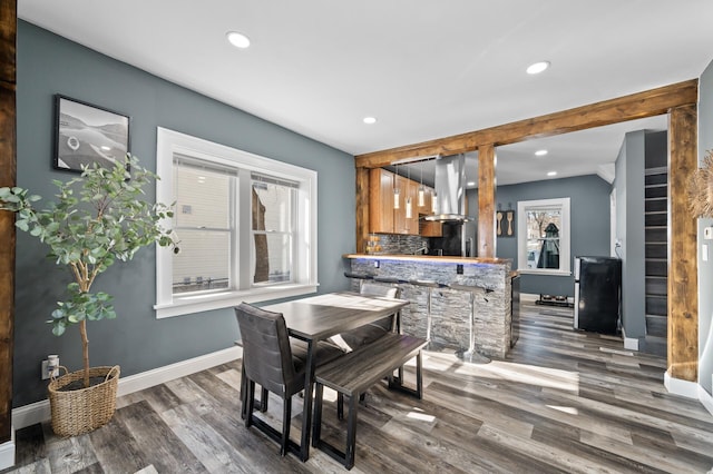 dining area with baseboards, wood finished floors, and recessed lighting