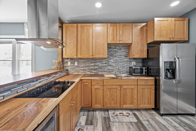 kitchen with a sink, appliances with stainless steel finishes, island exhaust hood, and tasteful backsplash