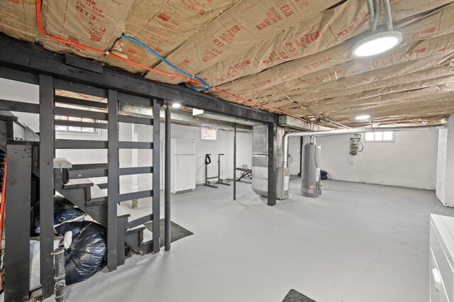 basement with heating unit, stairway, gas water heater, and freestanding refrigerator