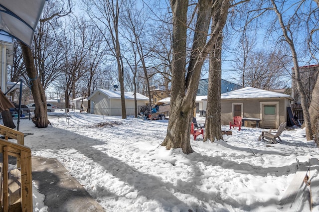 yard layered in snow featuring a garage and fence