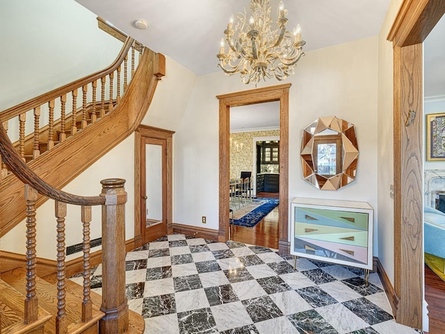 foyer featuring baseboards, a chandelier, and stairs