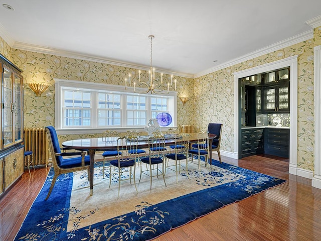 dining room with wallpapered walls, a notable chandelier, radiator, and wood finished floors