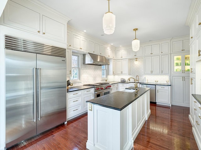 kitchen with high quality appliances, under cabinet range hood, a sink, dark wood-style floors, and white cabinets