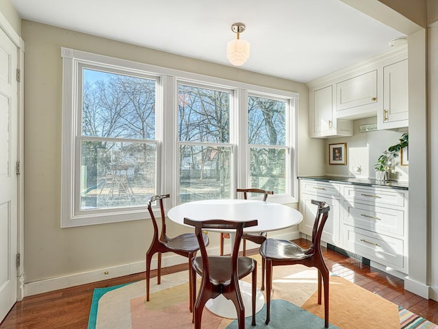 dining room with dark wood-type flooring and baseboards