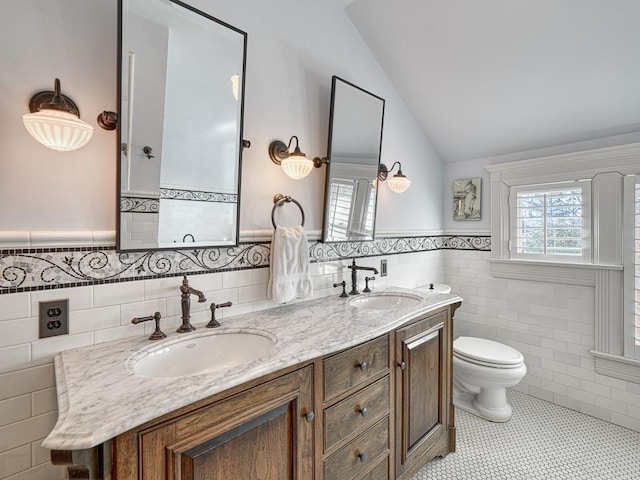 full bath featuring a sink, toilet, tile patterned flooring, and vaulted ceiling