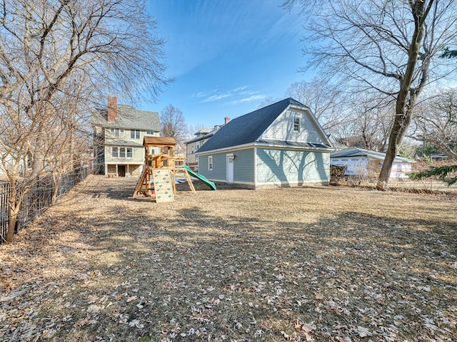 rear view of house featuring a playground and a chimney