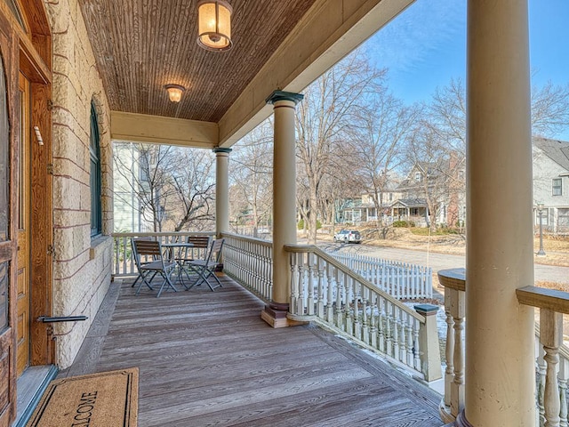 wooden terrace with a residential view and a porch