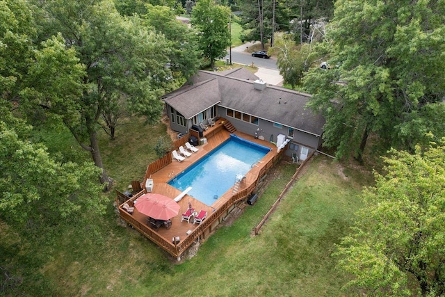 outdoor pool featuring a deck and a lawn