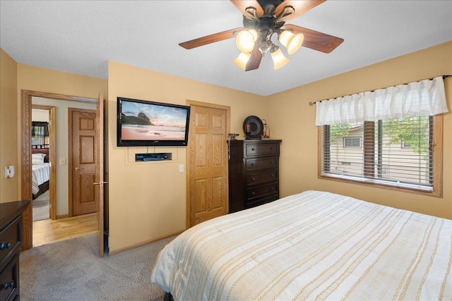 bedroom featuring light carpet, ceiling fan, and baseboards