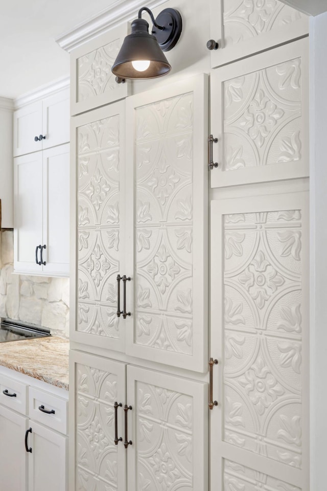 interior details with white cabinetry and light stone countertops