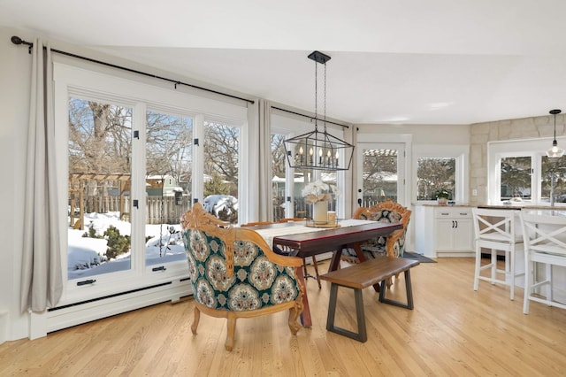 dining space with light wood finished floors and a baseboard heating unit