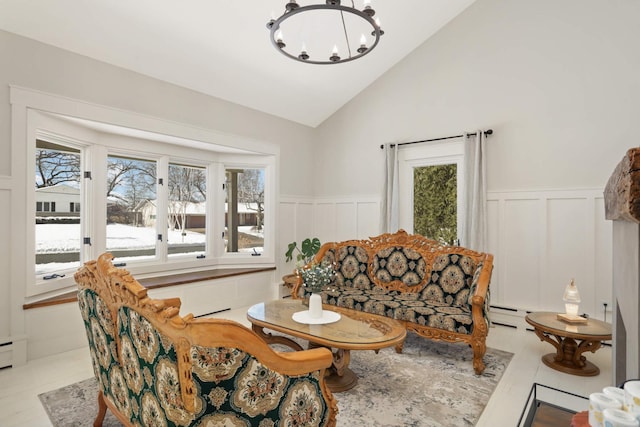 living room featuring lofted ceiling, light tile patterned floors, a chandelier, and wainscoting