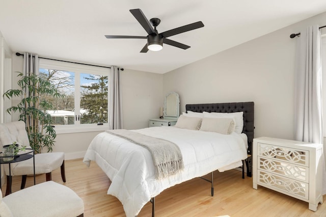 bedroom with lofted ceiling, ceiling fan, and light wood-style flooring