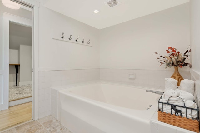 full bathroom featuring tile patterned flooring, visible vents, and a bath