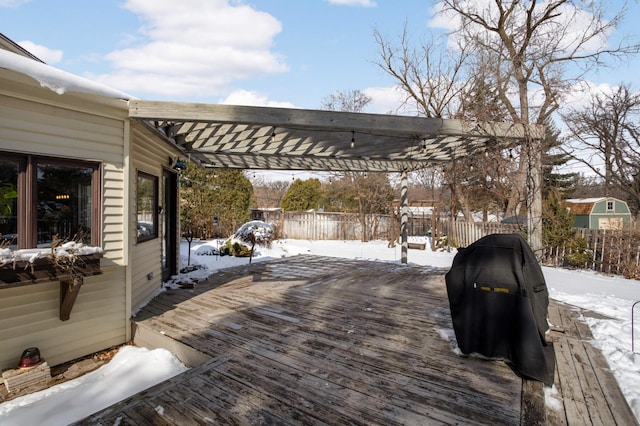 snow covered deck featuring fence, area for grilling, and a pergola