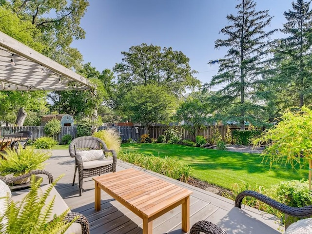 wooden deck featuring a fenced backyard, an outbuilding, a pergola, and a yard