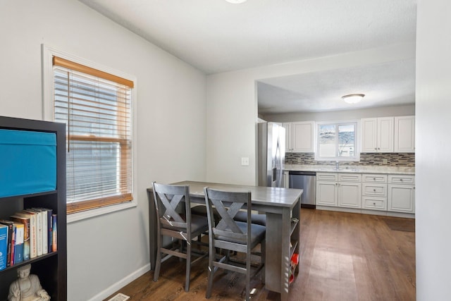 dining area featuring baseboards and wood finished floors