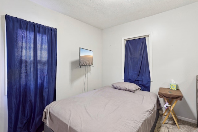 carpeted bedroom featuring baseboards and a textured ceiling