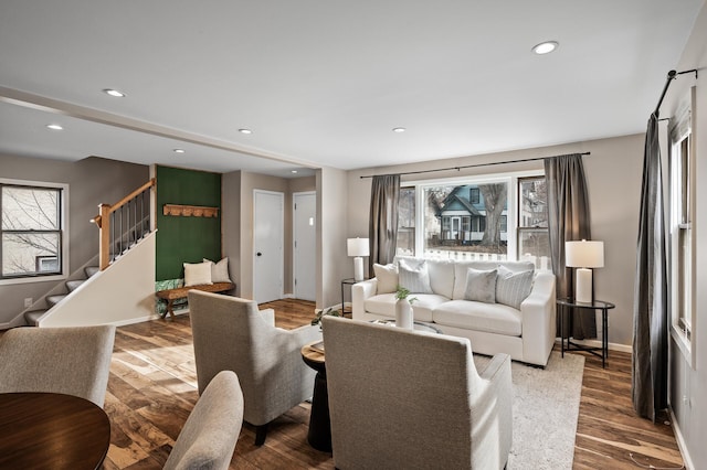 living room with recessed lighting, baseboards, wood finished floors, and stairs