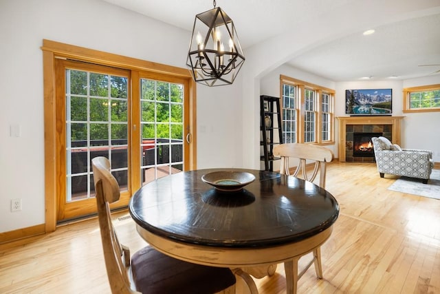 11050 Sweetwater Path, Woodbury, MN 55129 - dining area with light wood-style floors, a fireplace, a chandelier, baseboards, and recessed lighting