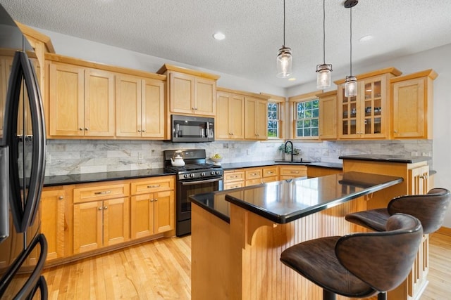 11050 Sweetwater Path, Woodbury, MN 55129 - kitchen with black appliances, a sink, a textured ceiling, a kitchen bar, and a kitchen island