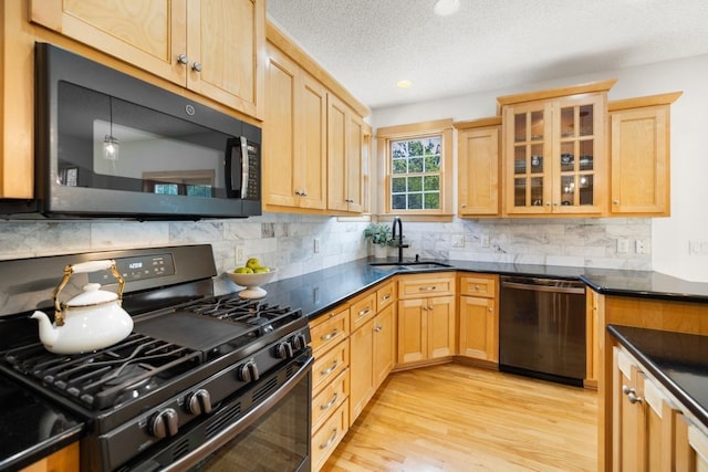 11050 Sweetwater Path, Woodbury, MN 55129 - kitchen with gas stove, dishwasher, black microwave, a sink, and light brown cabinetry