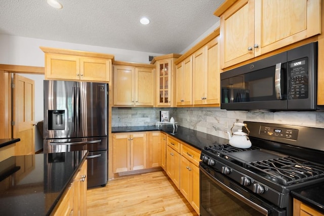 11050 Sweetwater Path, Woodbury, MN 55129 - kitchen with black appliances, dark stone countertops, light wood-style floors, light brown cabinets, and tasteful backsplash